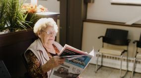 A resident browses through a magazine in the common room.